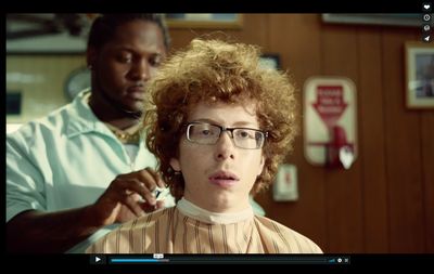 a woman getting her hair cut by a man