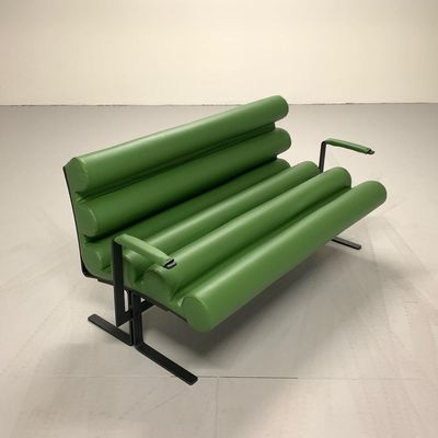 a green couch sitting on top of a metal frame