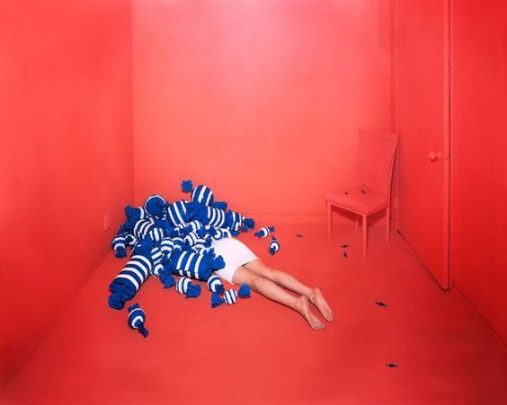 a person laying on the ground in a room with red walls