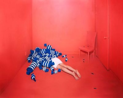 a person laying on the ground in a room with red walls