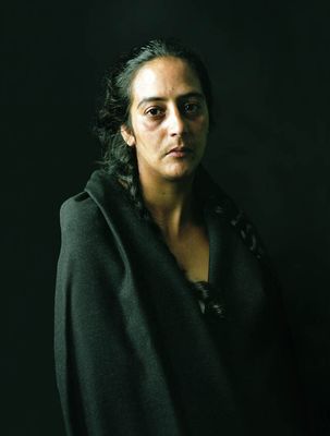 a woman in a black coat is posing for a picture