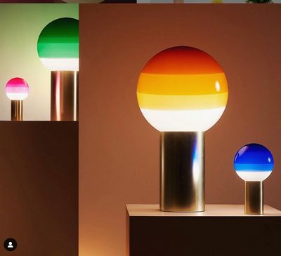 three different colored lamps sitting on top of a table