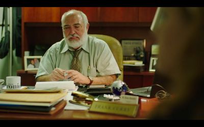 a man sitting at a desk with a cup of coffee