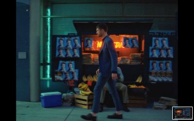 a man walking past a display of bananas