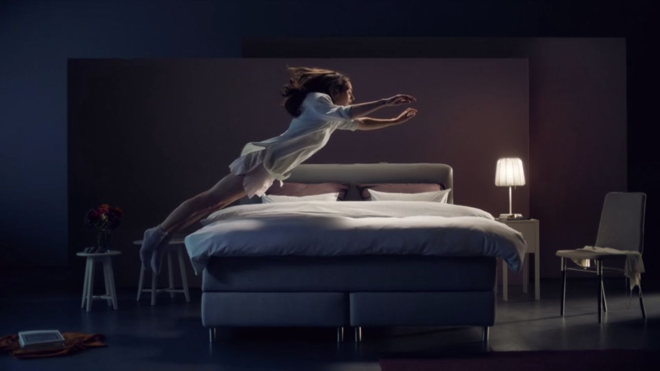 a woman in a white dress jumping on a bed