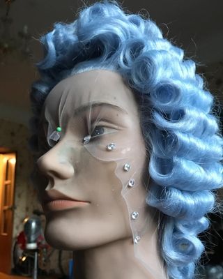 a mannequin head with a blue wig and pearls