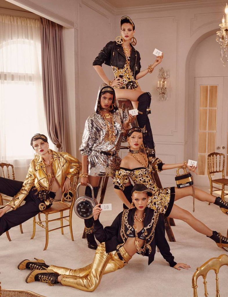 a group of women in gold and black outfits