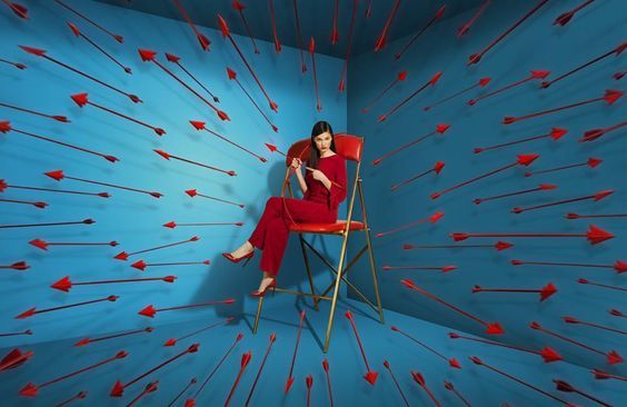 a woman sitting on a chair in a room with arrows