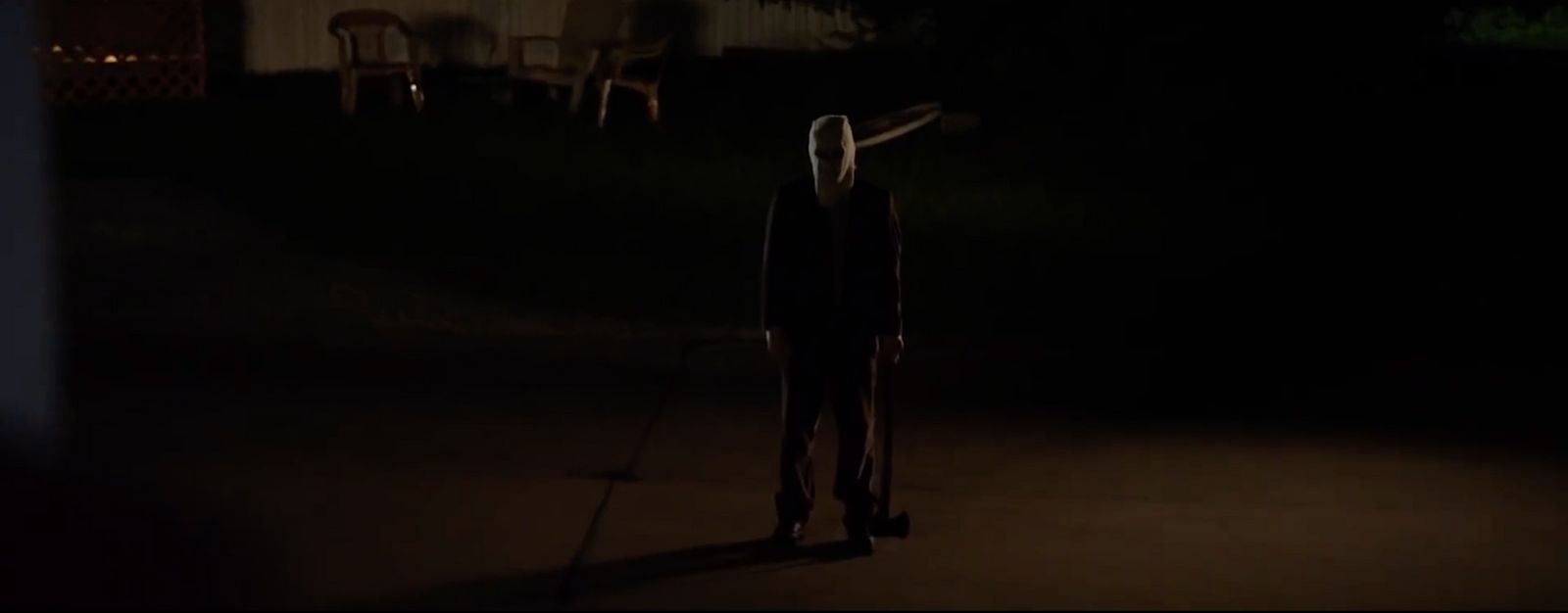 a person standing in the dark with a knife in their hand