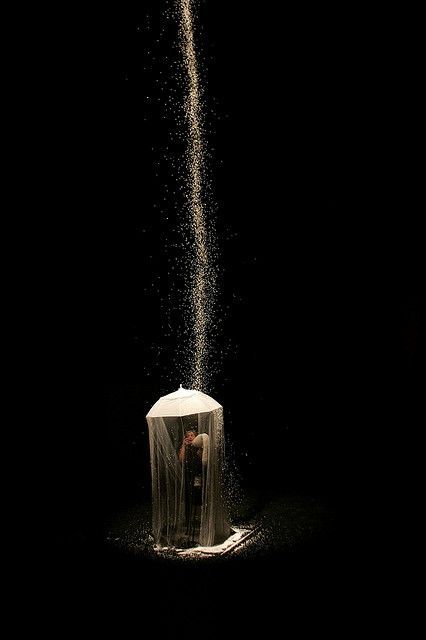 a person standing under a white umbrella in the dark