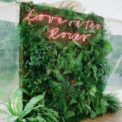 a green wall with a neon sign on it