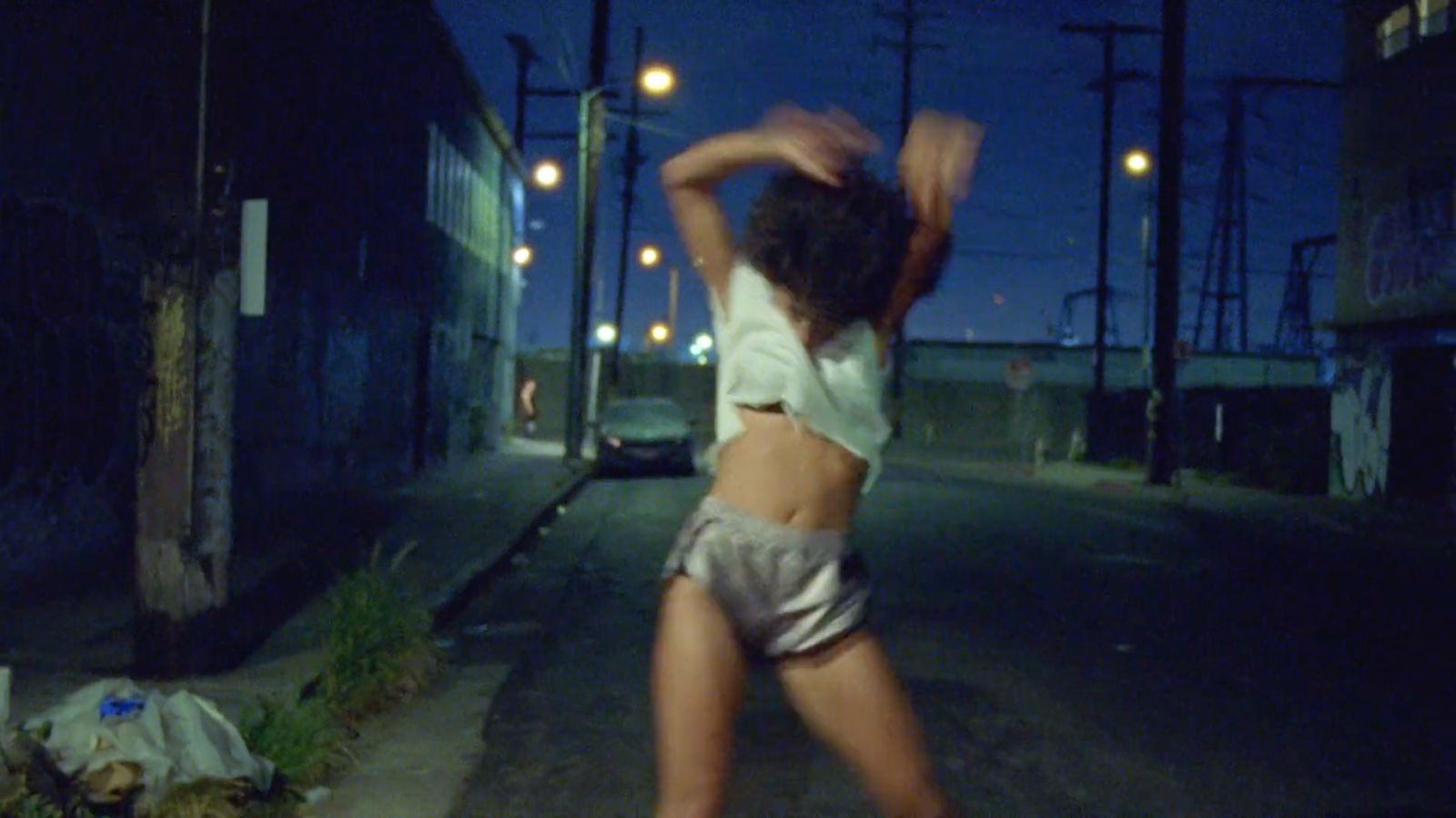 a woman is dancing on the street at night