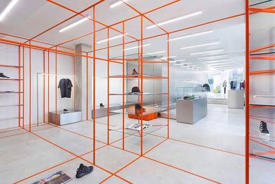 a white room with orange scaffolding and shoes on the floor