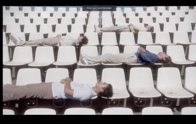 a couple of people laying on top of white chairs