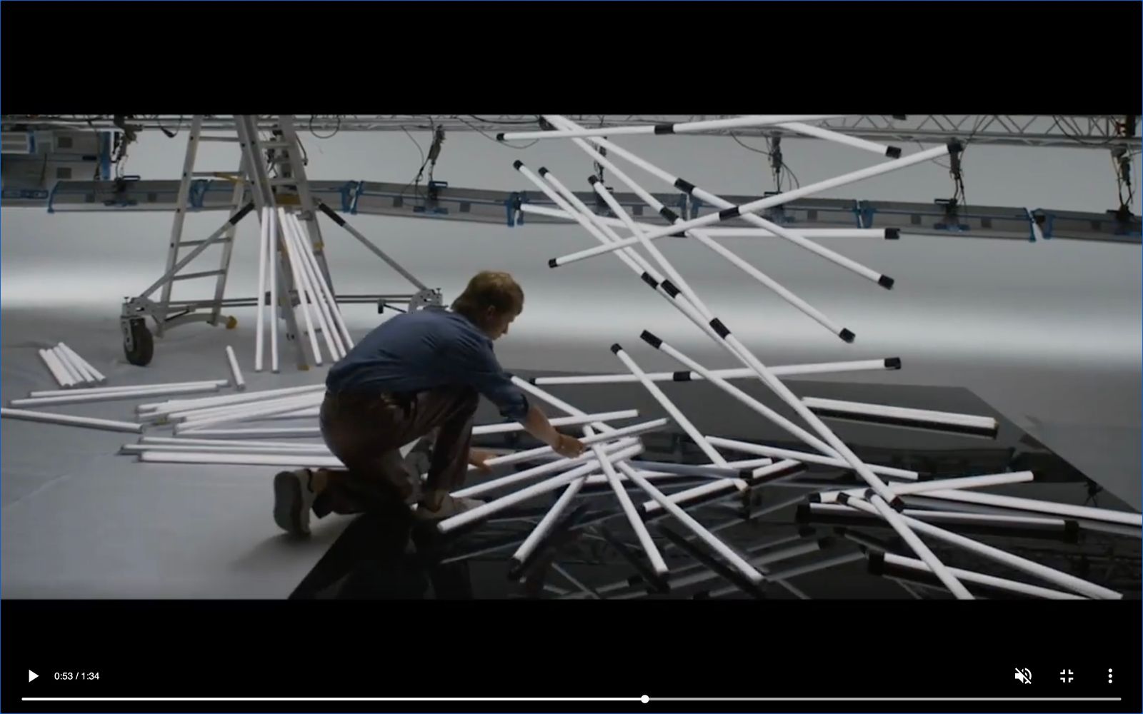 a man is working on a sculpture made of sticks