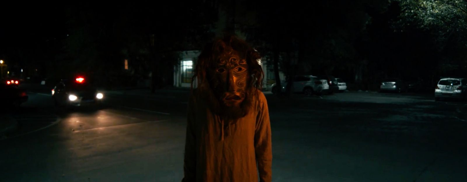 a person in a costume standing on a street at night