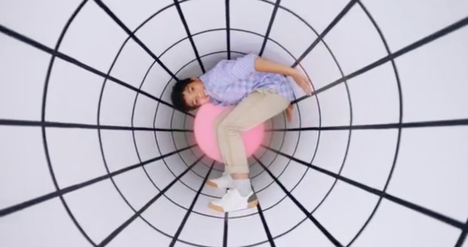 a man laying on top of a pink ball