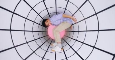 a man laying on top of a pink ball