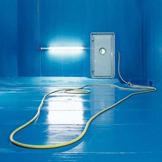 a blue room with a white box and a yellow hose