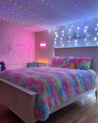 a bedroom with a bed covered in a colorful blanket