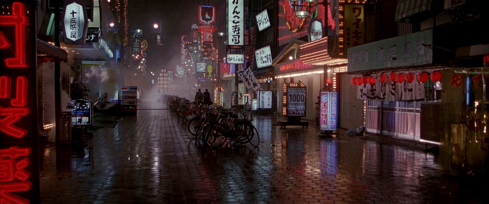 a city street at night with a lot of neon signs