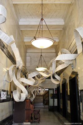 a long hallway with a chandelier hanging from the ceiling