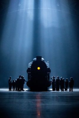 a group of people standing around a train on a stage