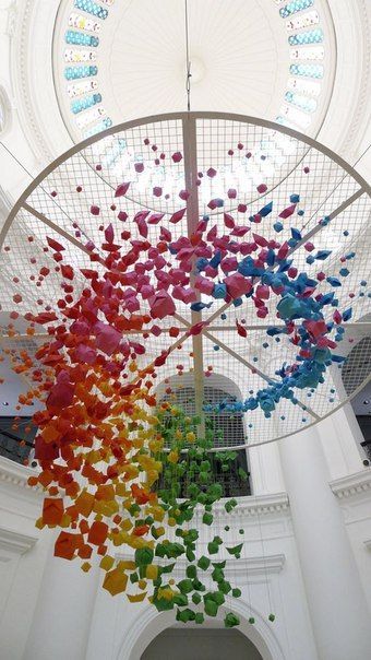 a multicolored sculpture hanging from the ceiling of a building