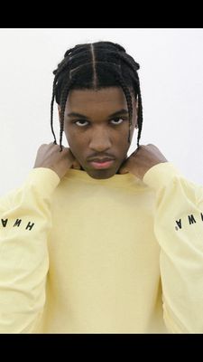 a man with dreadlocks wearing a yellow shirt