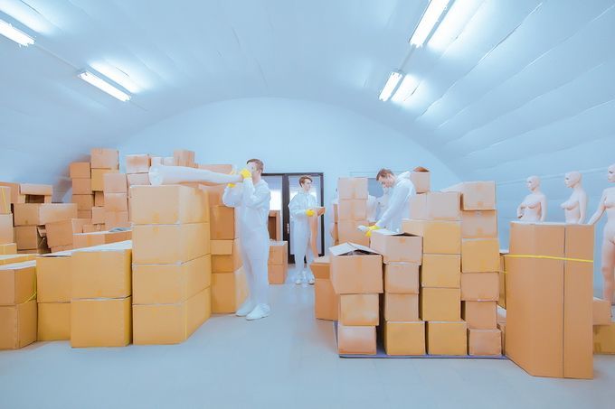 a group of men standing in a room filled with boxes