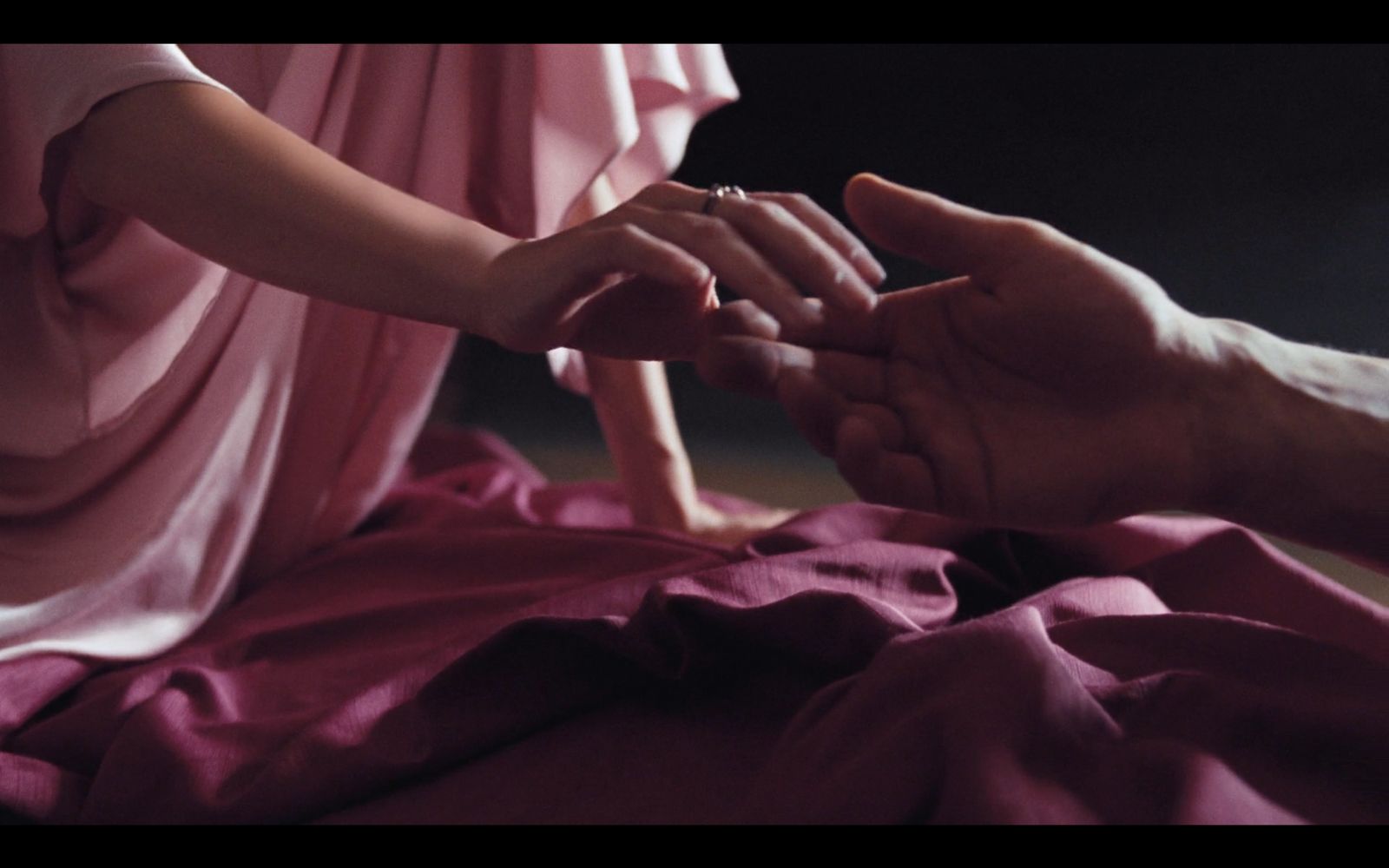 a man and a woman holding hands over a bed