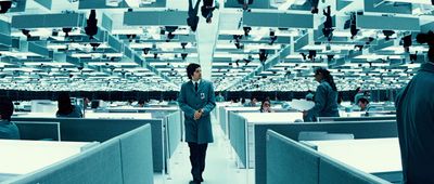 a woman standing in an office cubicle surrounded by cubicles