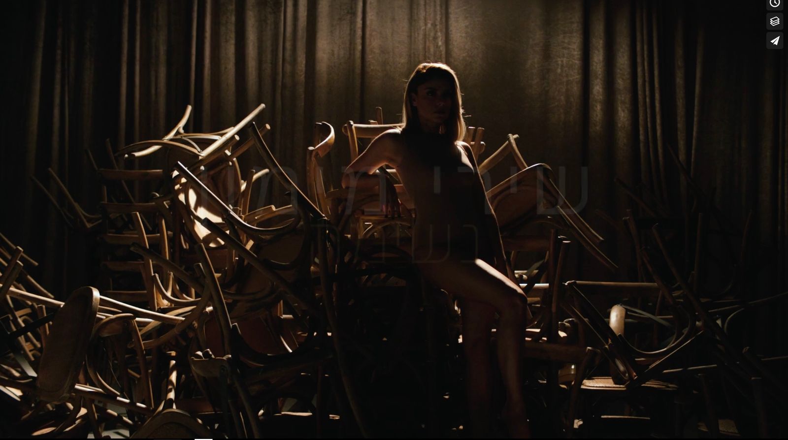 a woman sitting on a chair in a room full of chairs