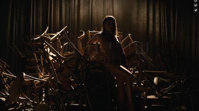 a woman sitting on a chair in a room full of chairs