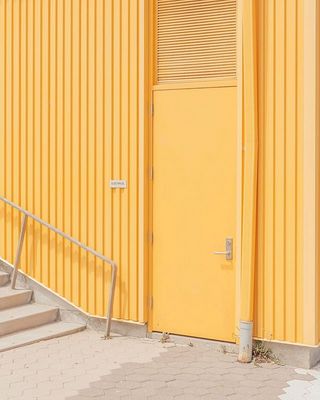 a yellow building with stairs leading up to it