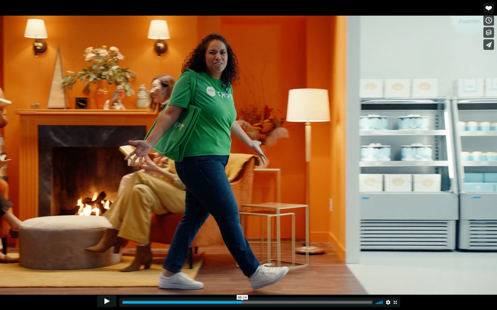 a woman in a green shirt is walking in a living room