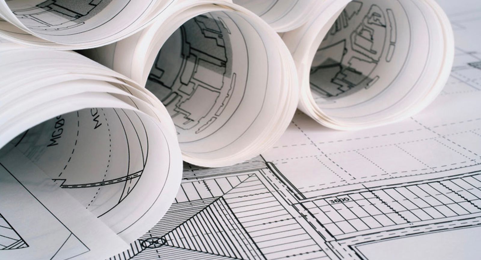 rolls of architectural drawings on top of a blueprint