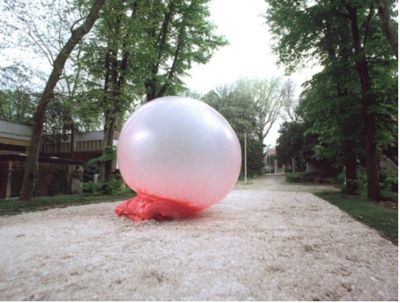 a large white ball sitting on top of a sandy ground