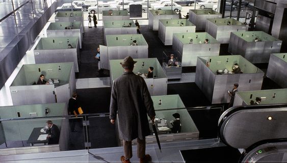 a man standing in a room filled with cubicles