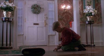 a young boy sitting on the floor in front of a door