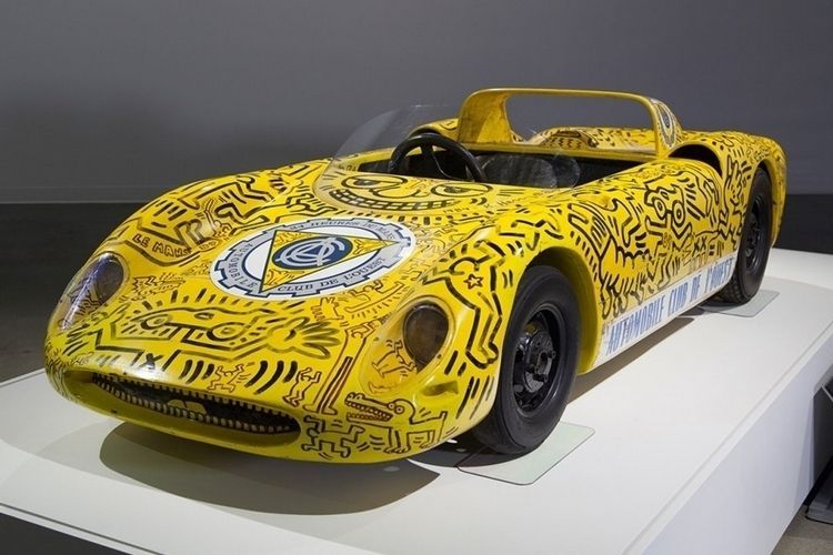 a yellow sports car is on display in a museum