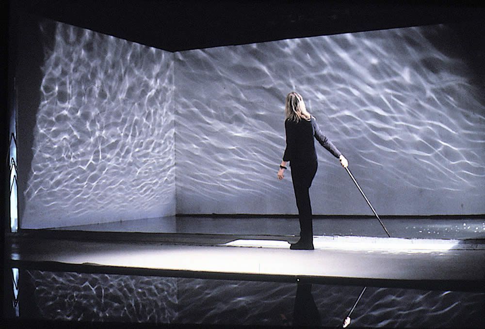 a woman standing on a stage with a mop