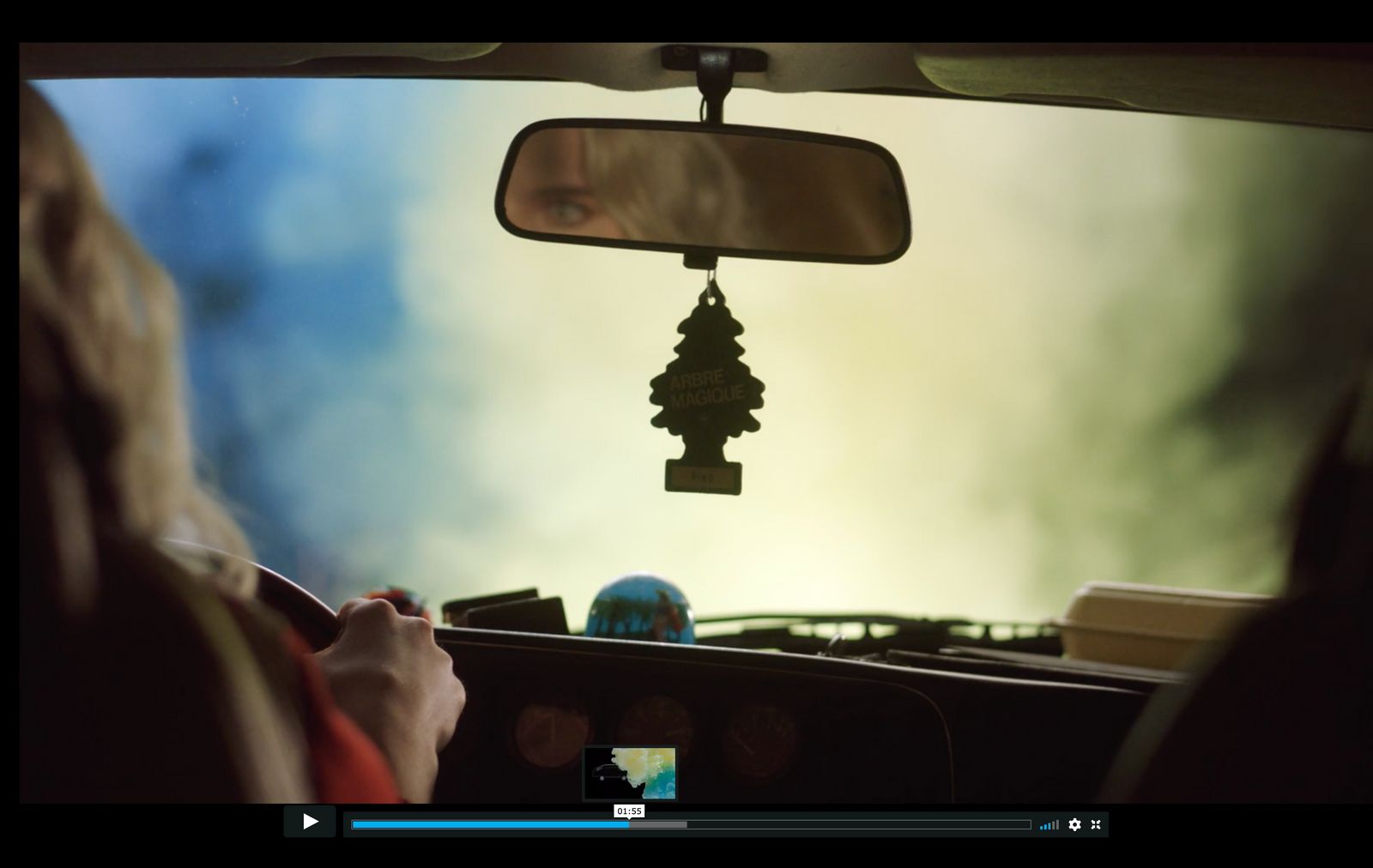 a woman driving a car while holding a cell phone