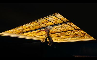 a person walking in front of a lit ceiling