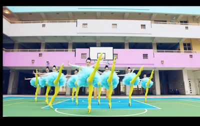 a group of people standing on top of a basketball court