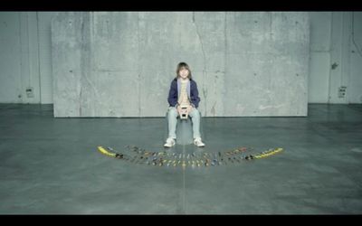 a girl sitting on a string with a dog in front of her