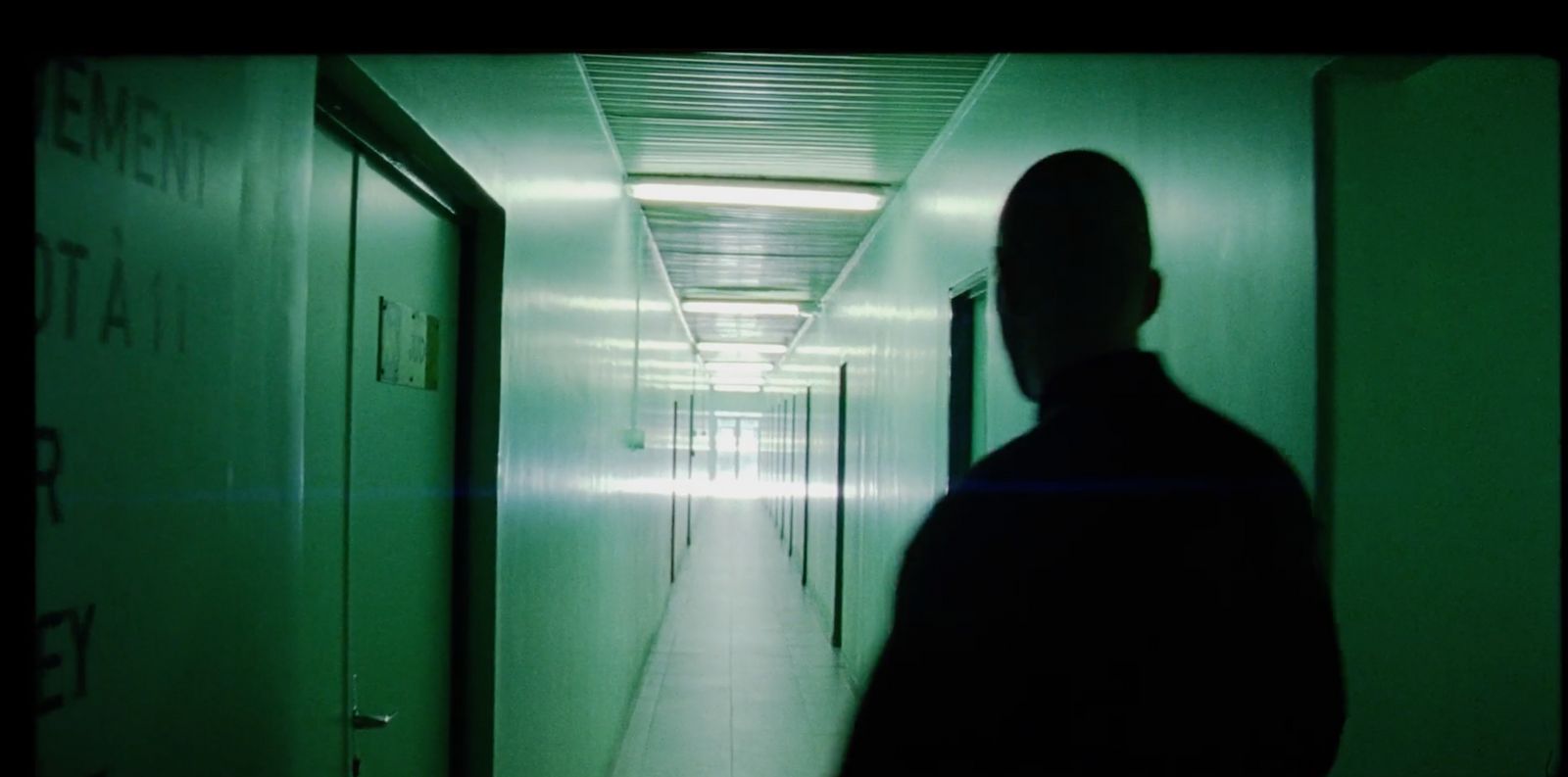 a man walking down a long hallway in a building