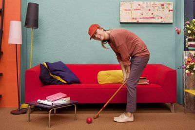 a woman playing a game of croquet in a living room