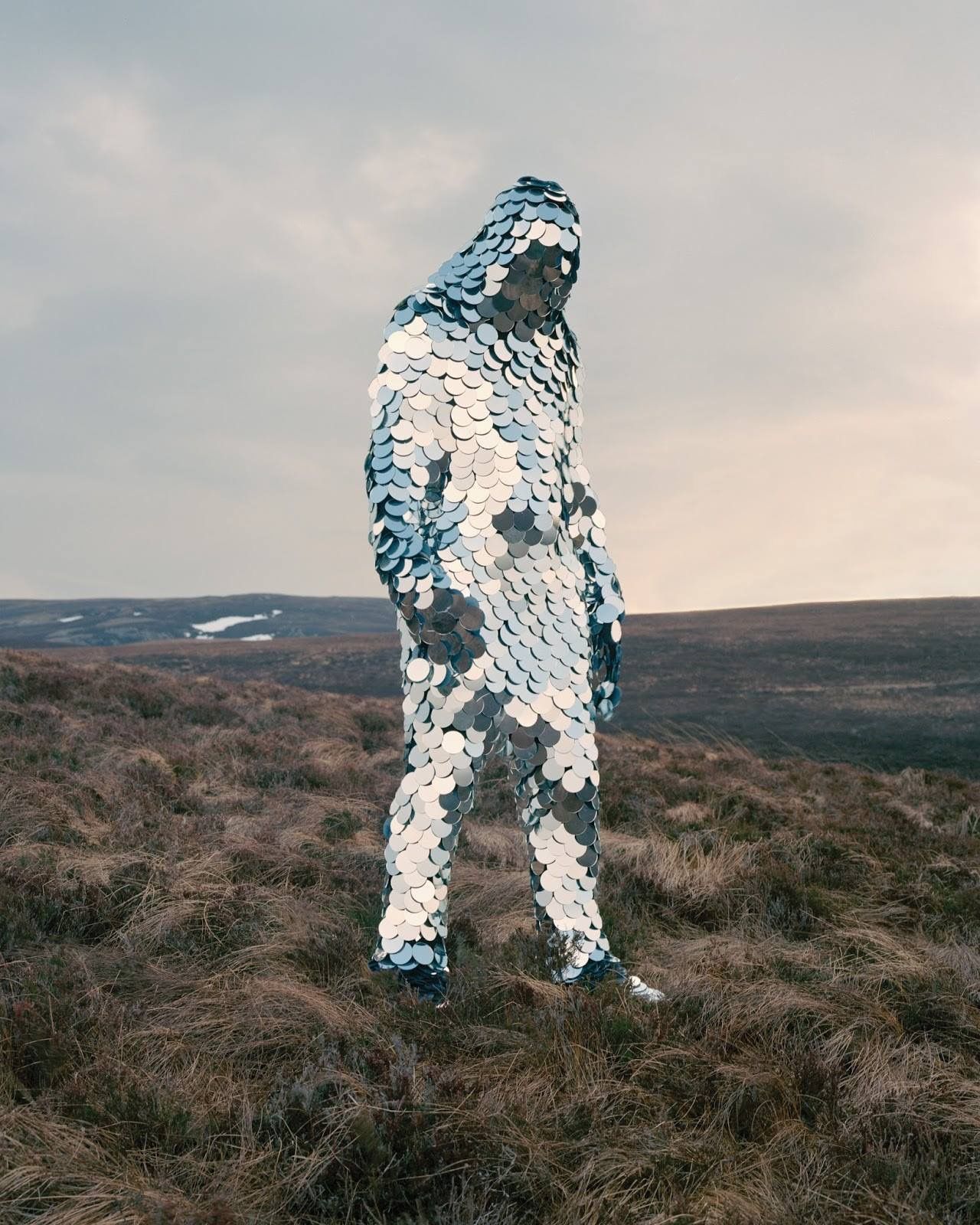 a man standing on top of a grass covered field