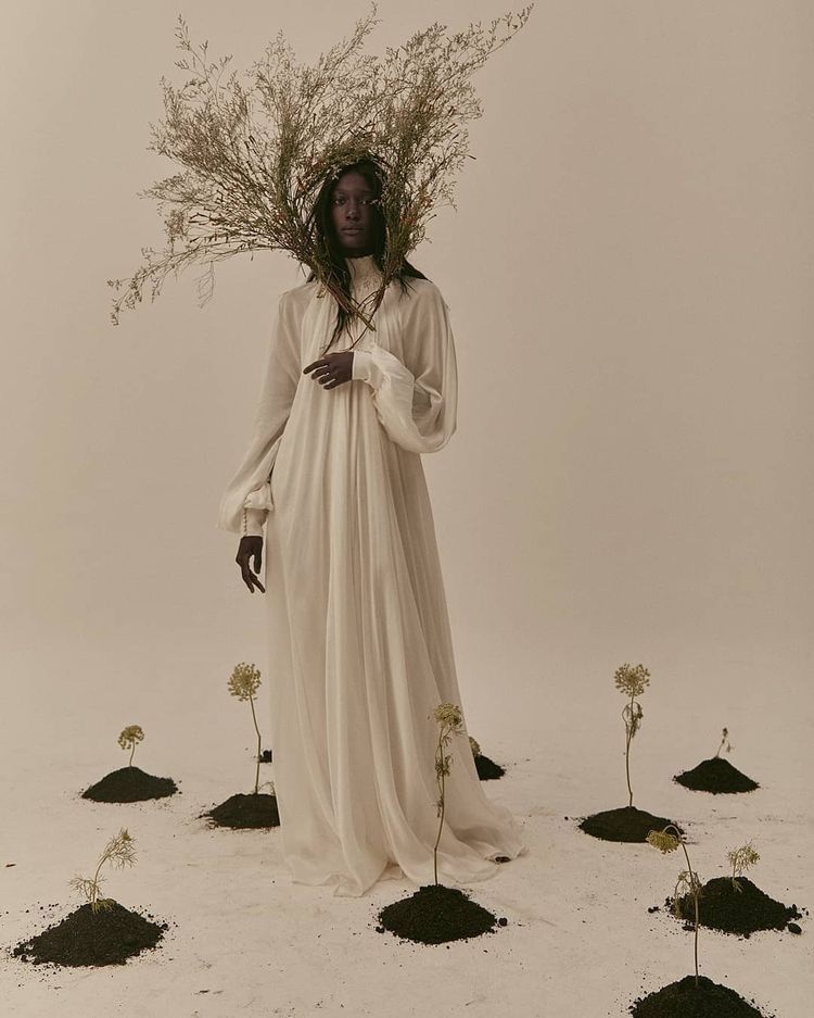 a woman in a white dress holding a bunch of flowers